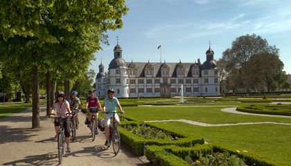 Radfahrer vor dem Schloss Neuhaus in Paderborn