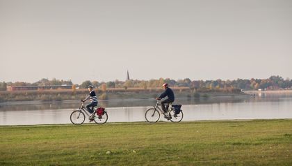 Zwei Radfahrer fahren entlang des Rheinufers in Wesel