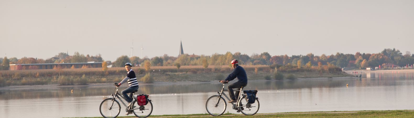 Zwei Fahrradfahrer fahren entlang des Rheinufers in Wesel